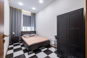 a bedroom with a bed and a checkered floor at Diva in Saint Petersburg