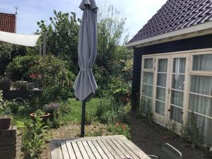 an umbrella sitting on a table in a garden at Zomerhuisje op Huisduinen in Huisduinen