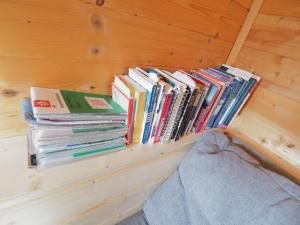 ein Stapel Bücher, die auf einem Regal in einem Raum liegen in der Unterkunft Tiny Sport base in Innsbruck