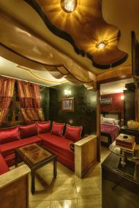 sala de estar con sofá rojo y cama en Résidence Hoteliére Chez Aziz, en Chefchaouen