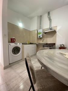 eine Küche mit einer Waschmaschine und einem Tisch in der Unterkunft Like home 2 in Salta
