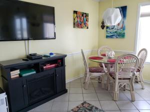 a dining room with a table and a flat screen tv at A Place at the Beach 406 in Myrtle Beach