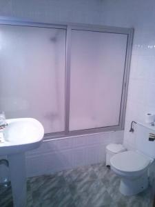 Łazienka z białą toaletą i umywalką w obiekcie Pension Rioja w mieście Quinto