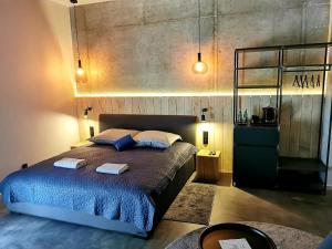 1 dormitorio con 1 cama con 2 toallas en Apartamenty Dobry Browar, en Gniezno