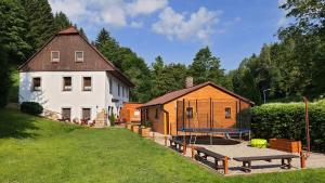 a backyard with a house and a table tennis court at Penzion Čtyřlístek in Teplice nad Metují