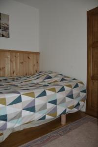 een slaapkamer met een bed met een kleurrijk dekbed bij Heaven in Treignes