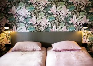 1 dormitorio con 2 camas y papel pintado con motivos florales en Vakantiehuisje De Barones, en Middelburg
