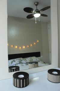 a bedroom with a bed and two stools in front of a mirror at ACOGEDOR APARMENTO JUNTO AL CENTRO in Huelva
