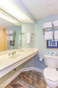 een badkamer met een wastafel, een toilet en een spiegel bij Boardwalk 1030 in Myrtle Beach