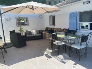 een patio met een tafel en stoelen en een parasol bij Maisonnette Cagnes in Cagnes-sur-Mer