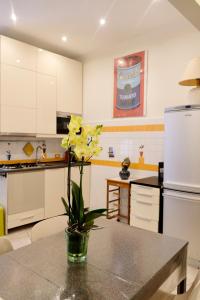 une cuisine avec un vase avec des fleurs jaunes sur une table dans l'établissement New Apartment Sistina 2, à Rome