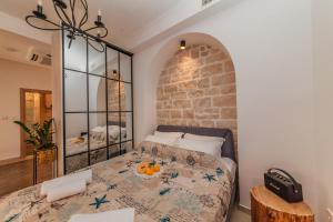 a bedroom with a bed and a stone wall at Apartments Belvedere in Herceg-Novi