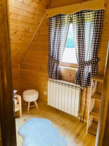 a room with a window and a rug in a cabin at Holiday Homes Durmitorski Gaj in Žabljak