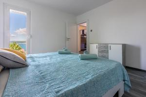 a bedroom with a large bed with a large window at Apartment PEK in Crikvenica