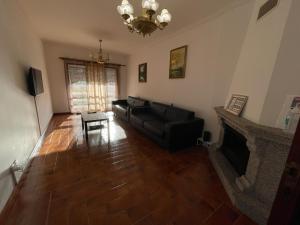 a living room with a black couch and a fireplace at Barra Sol - Lighthouse on the Beach in Praia da Barra