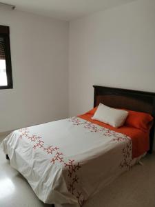 1 dormitorio con 1 cama con manta roja y blanca en Bonita casa con piscina privada, en Villafranca de Córdoba