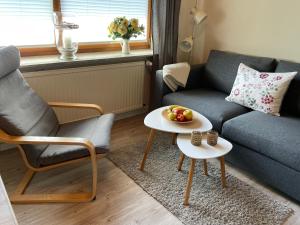 uma sala de estar com um sofá e uma mesa com fruta em Ferienwohnung von Luehmann em Niebüll