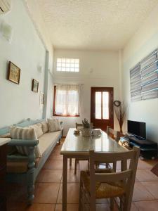 een woonkamer met een bank en een tafel bij Patra's home in Ándros