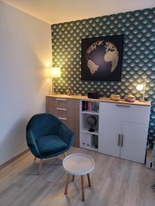 a living room with a blue chair and a desk at Studio bien équipé, situé en hyper centre in Vendôme