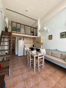 a kitchen and living room with a table and a couch at Patra's home in Andros