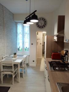 a kitchen with a table and a dining room at Le petit Saint Bernard in Dijon