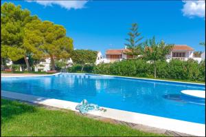 a large blue swimming pool in a yard with houses at Bungalow Blue Dream 3 - Sea views, terrace and pool in Gran Alacant