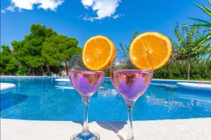 dos copas de vino con rodajas de naranja frente a una piscina en Bungalow Blue Dream 3 - Sea views, terrace and pool, en Gran Alacant