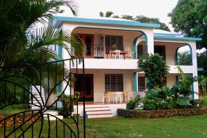 a white house with a blue roof at Apart-Hotel Garden Villa in Las Galeras