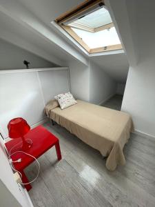 Mały pokój z łóżkiem i czerwonym krzesłem w obiekcie La manga arriba w mieście La Manga del Mar Menor