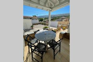 a table and chairs on a patio with a view at PANOS ROOMS Modern 3-Bedroom apartment in Andros