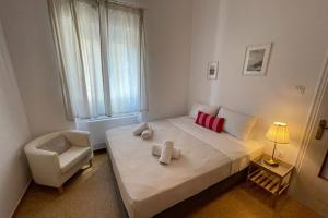 a bedroom with a bed and a chair and a window at PANOS ROOMS Modern 3-Bedroom apartment in Andros