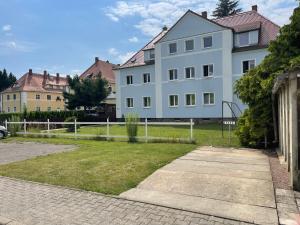 una grande casa bianca con parco giochi nel cortile di NEU Familienfreundliche FeWo in Seennähe im Leipziger Süden a Markkleeberg