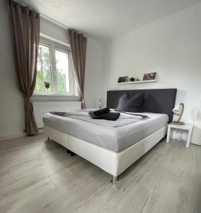 - une chambre avec un grand lit blanc devant une fenêtre dans l'établissement NEU Familienfreundliche FeWo in Seennähe im Leipziger Süden, à Markkleeberg