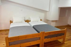 dwa łóżka siedzące obok siebie w pokoju w obiekcie PANOS ROOMS Beachfront apartment with Loft w mieście Andros