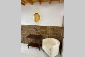 a bathroom with a chair and a table and a mirror at PANOS ROOMS Central loft studio near the beach in Andros +1 photo