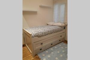 a small bedroom with a bed with a window at La casa del centro in A Coruña