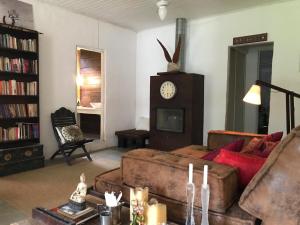 een woonkamer met een bank en een klok aan de muur bij Casa Crudo, PRIVACIDADE NA MATA ATLÂNTICA, piscina, trilhas e descanso in Salesópolis