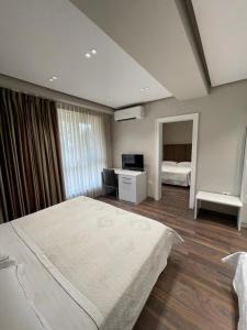 a bedroom with two beds and a desk in it at Hotel Oresti Center in Tirana