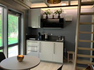 a kitchen with white cabinets and a table at Putnu pirts in Saulkrasti