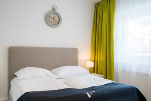 a bedroom with a bed and a clock on the wall at Vienna Residence, Rochusmarkt - Wien Mitte in Vienna