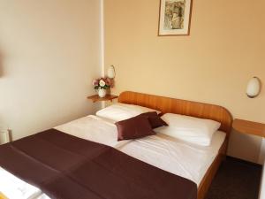 a bedroom with a bed with white sheets and a wooden headboard at Room in Rakovica with WiFi 4958-5 in Rakovica