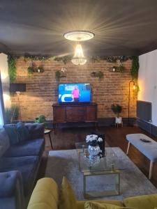 a living room with a couch and a tv at Albert Rd Aparthotel in Colne