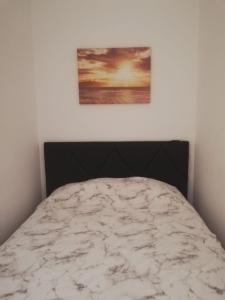 a bed in a bedroom with a painting on the wall at Flamingo Apartment in Portimão