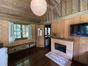 a living room with a fireplace and a tv at Kanawha Hotel in São Pedro da Serra