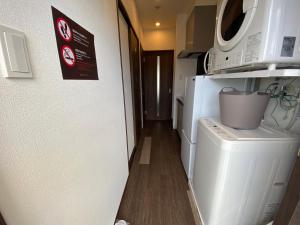 a laundry room with a washing machine and a microwave at HOTEL GranLeaf Miyakojima in Miyako-jima