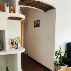 a living room with white walls and a wooden floor at AMANECER Rent Apart - Tú Hogar! Amplio y Luminoso con Desayuno in Junín