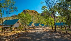 a row of houses with a mountain in the background at Emma Gorge Resort at El Questro in Kununurra