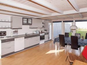 a kitchen and dining room with a table and chairs at 6 person holiday home in Hemmet in Falen