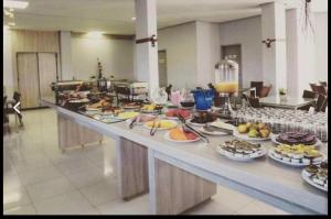 a buffet line with many plates of food and drinks at FLAT VEREDAS RIO QUENTE Apto 113 in Rio Quente