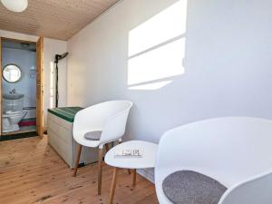 Zimmer mit 2 weißen Stühlen und einem Tisch in der Unterkunft 6 person holiday home in L kken in Løkken